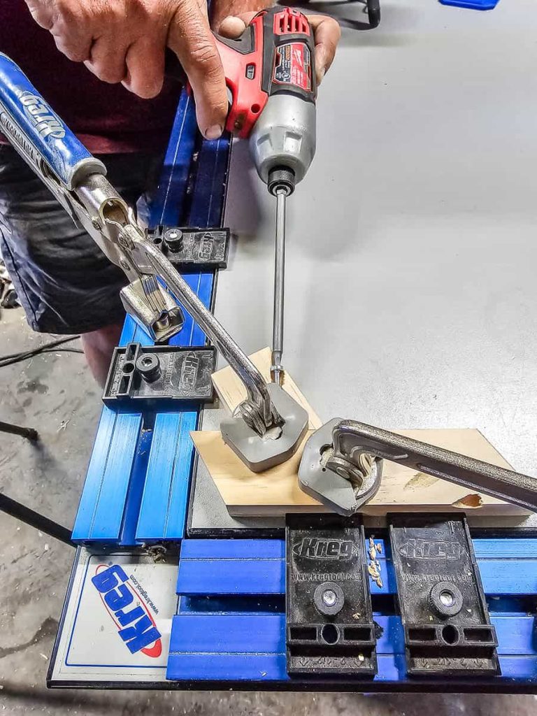 A person is employing a Kreg clamp to secure the leg of the Chicknic Table.