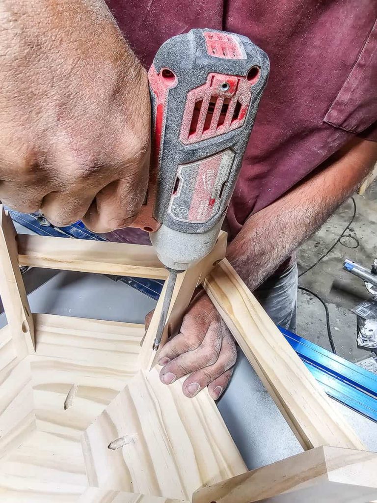 The man is drilling the pocket holes for the Chicknic Table.