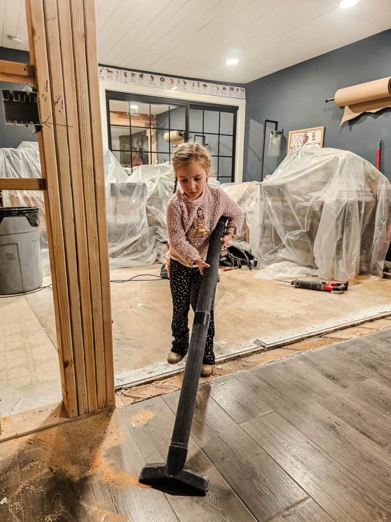 Girl helping clean up renovation debris and dust with shopvac