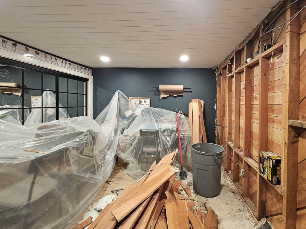 Furniture in room covered with plastic sheeting to help with dust from renovation 