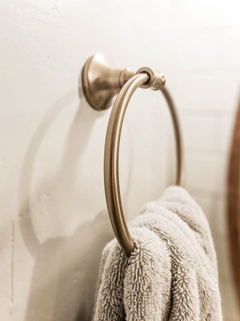 Round towel ring with gray towel hanging on it - Delta Chamberlain Towel Ring in Champagne Bronze