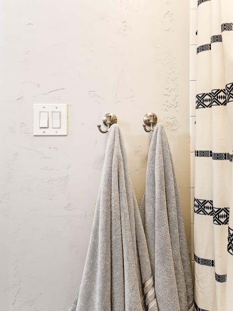 Towel or robe hooks are a perfect way to save space in a small bathroom. We love these hooks in champagne bronze with fluffy gray turkish towels