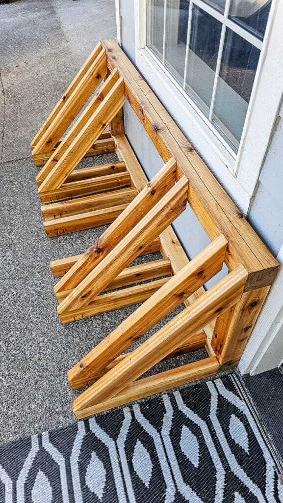 The finished DIY bike rack is set up outside the house.
