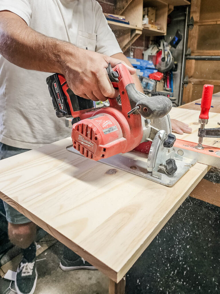 In building floating bookshelves, a man is trimming the wood to the required dimensions.
