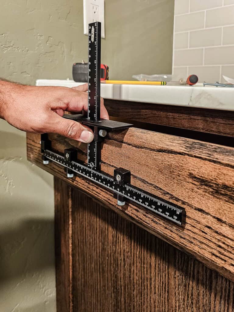 A photo of hardware being added to the cabinets, completing the DIY built-in project for the dining room.