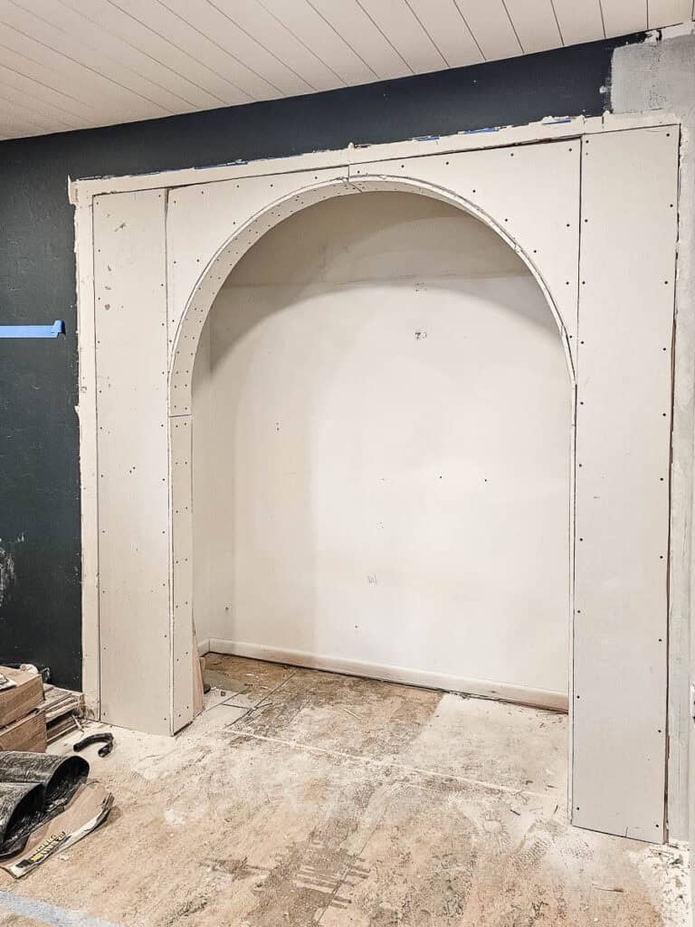 Drywall covering arched opening of a nook that used to be a reach-in closet 