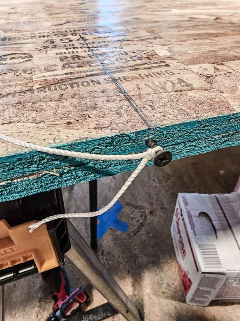 Screw with string tied to it to make a semi-circle shape with marker