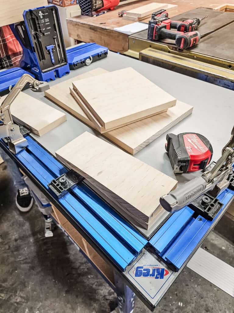A photo of a freshly cut wooden board, ready to be assembled into a small bookshelf from a single piece of wood.