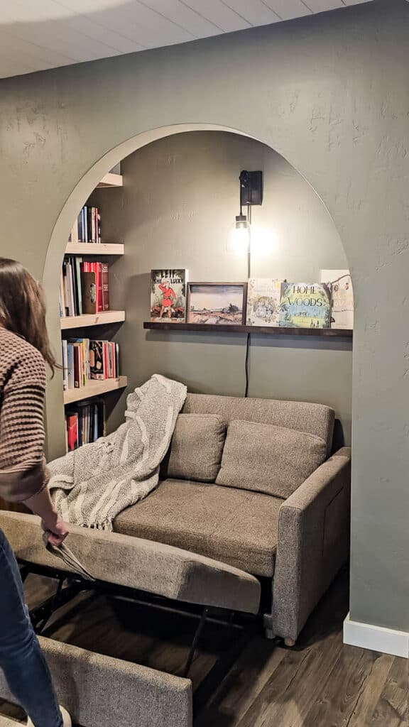 Reading nook with small convertible sofa with pull out foot rest being pulled out 