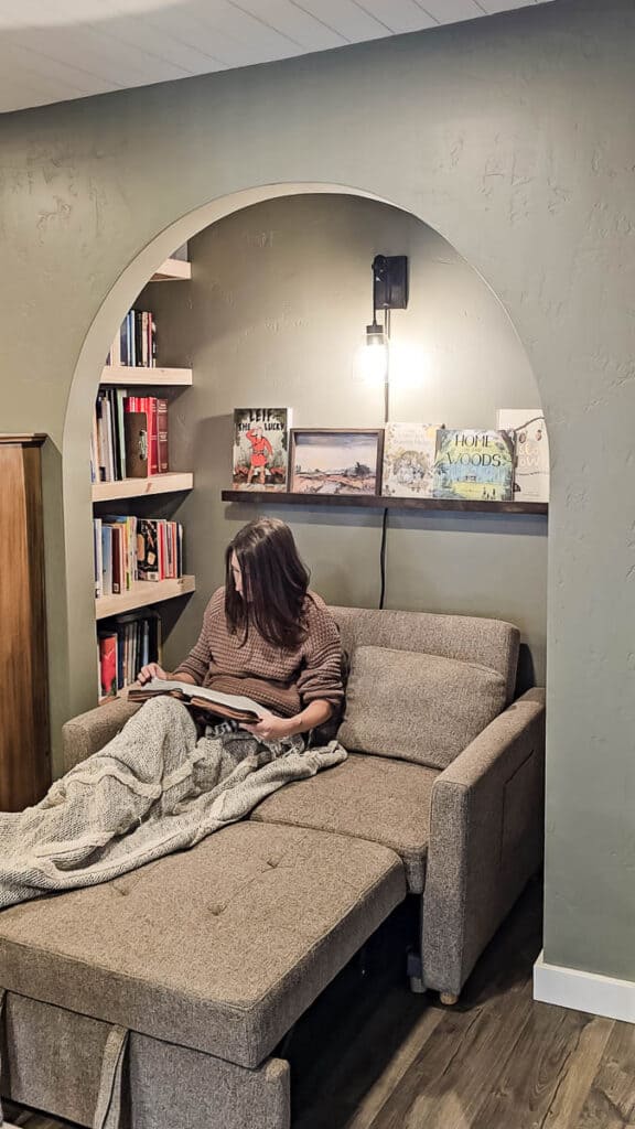 Woman reading bible sitting on small couch