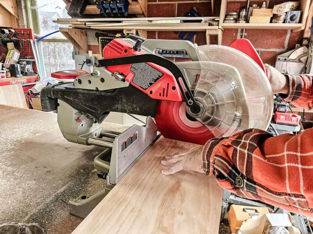 A photo of a miter saw cutting a wooden board to craft a small bookshelf from a single piece of wood.