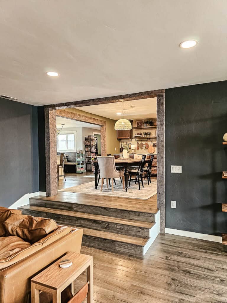 Openings in the walls between living room, kitchen and dining room with fake wood beams that look old