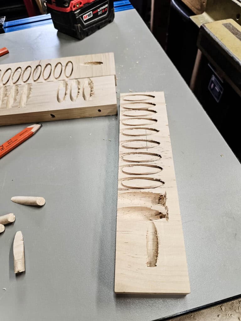 A photo of a wooden board positioned in a pocket hole jig, with a special drill bit being used to drill holes for plugs, ensuring precise and secure assembly for a small bookshelf project.