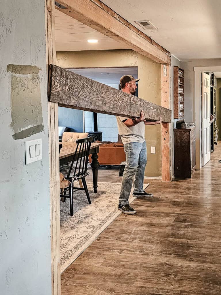 Lifting fake wood header beam into opening while installing
