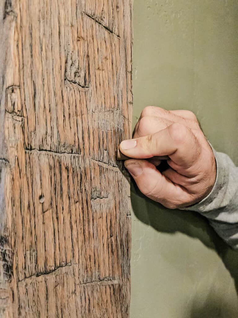 Rubbing Blend Stick over nail hole in fake wood beam to cover it
