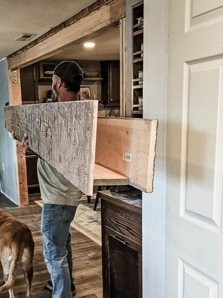 Showing the end of the U-shaped fake wood beams being brought into the house to install 