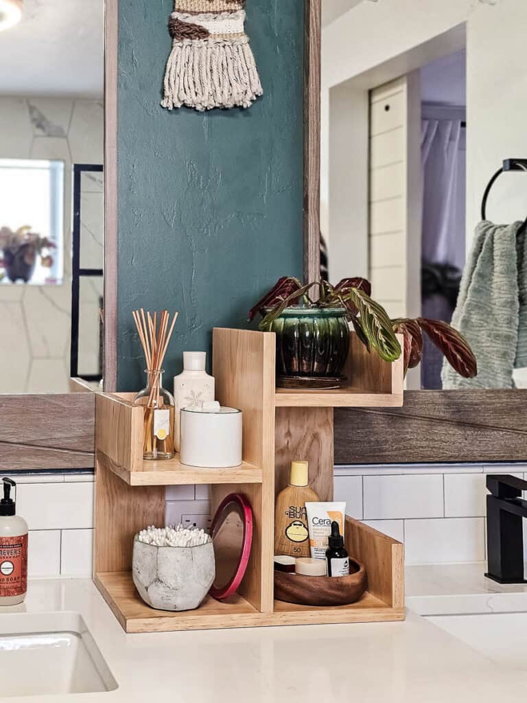 A photo of the finished small bookshelf, now used to organize plants, lotions, skincare items, sunscreen, Q-tips, and more. This versatile piece adds a stylish touch while keeping everyday essentials neatly arranged and easily accessible.