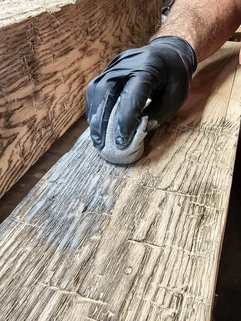 Adding classic gray stain to fake wood beams after distressing the wood
