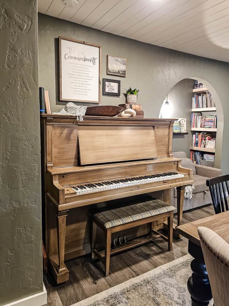 Another photo of an upright piano in a traditional-style dining room.