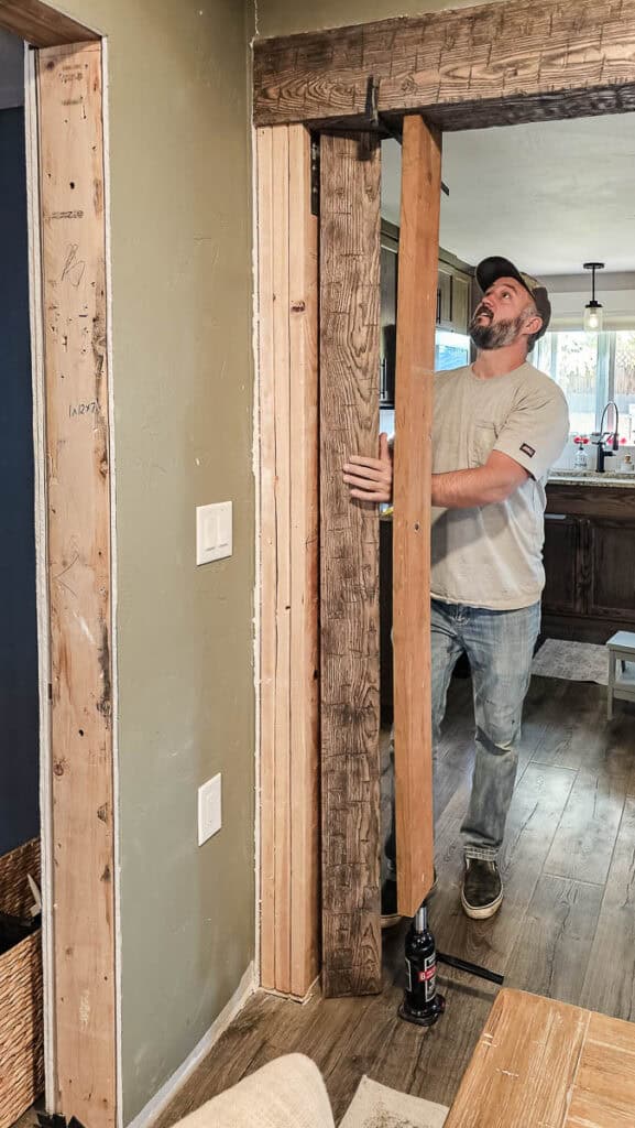 Installing vertical side wood beam around cased opening