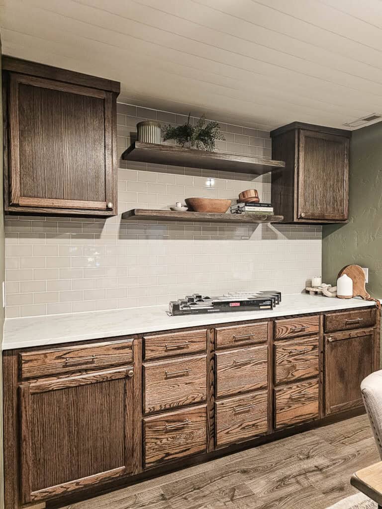 Another reveal photo showcasing the completed application of the Musselbound Adhesive Tile Mat, with two cabinets on either side and some decorative accents.