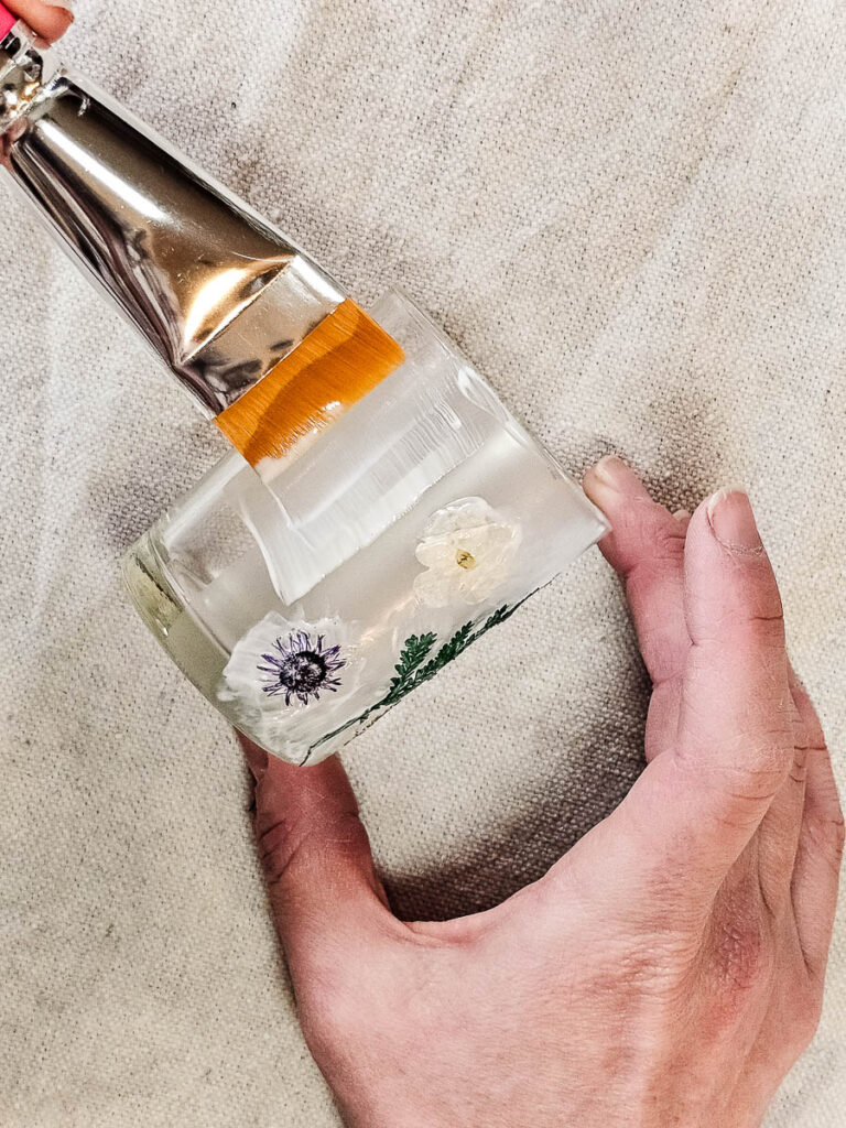 A person painting the glass with a brush.
