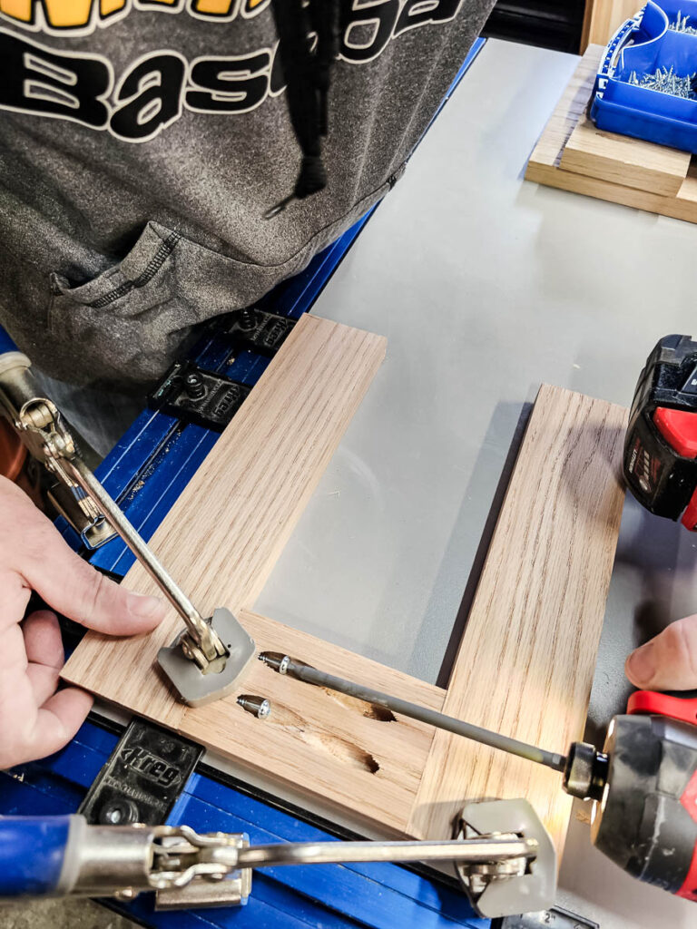 A photo of a man assembling the top and legs using pocket hole screws.
