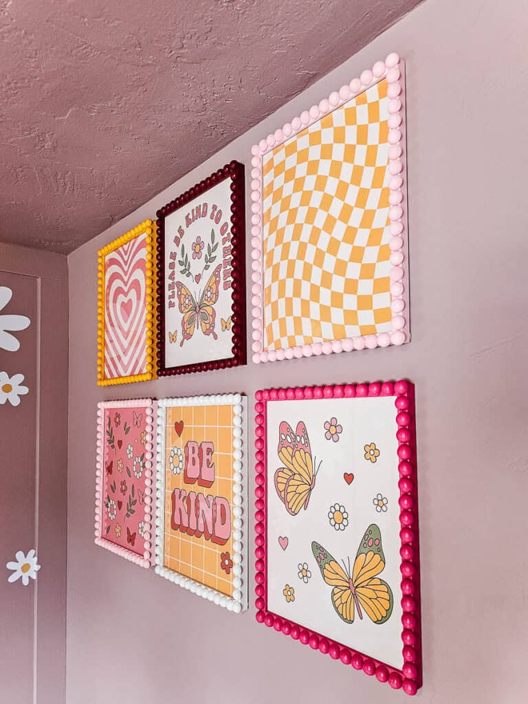 A detailed close-up of six finished wooden bobbin picture frames hanging on the wall, highlighting their vibrant colors and intricate design.