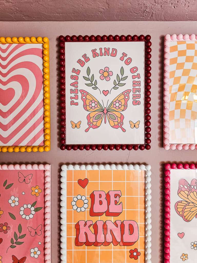 A zoomed-in view of six colorful wooden bobbin picture frames displayed on the wall, showcasing their handcrafted details.