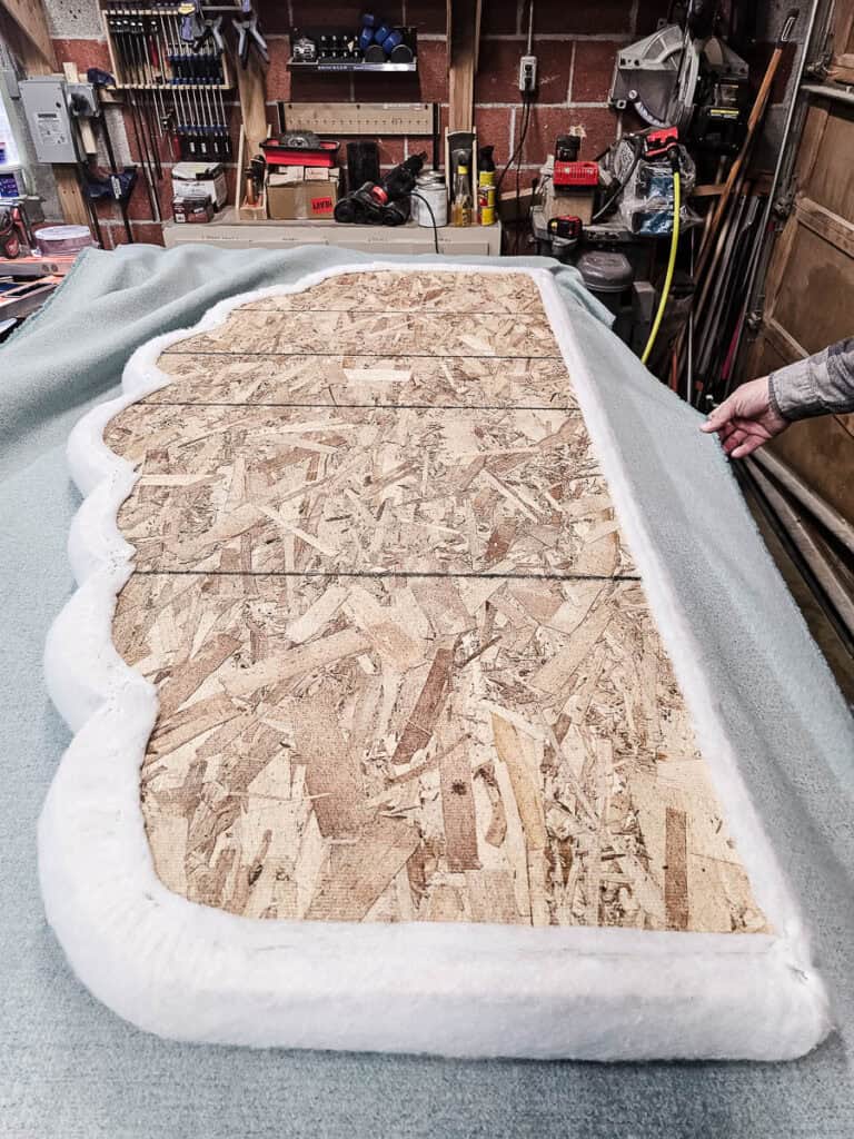 Batting attached with staples on the headboard before attaching fabric when upholstering