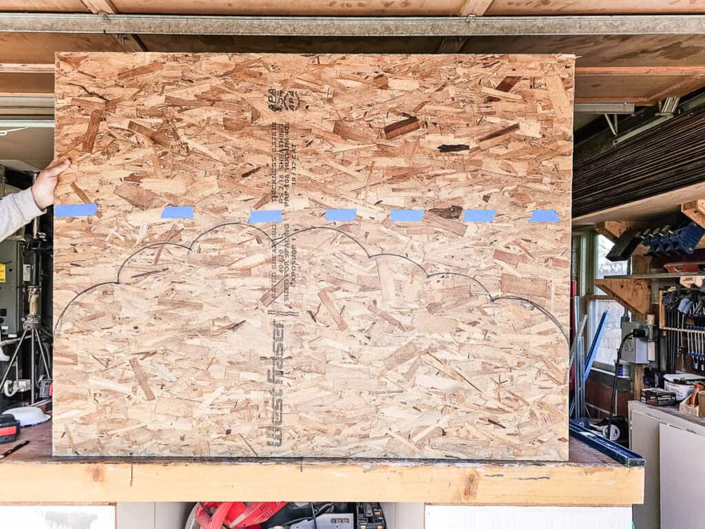 A piece of OSB wood marked with a cloud-shaped outline.