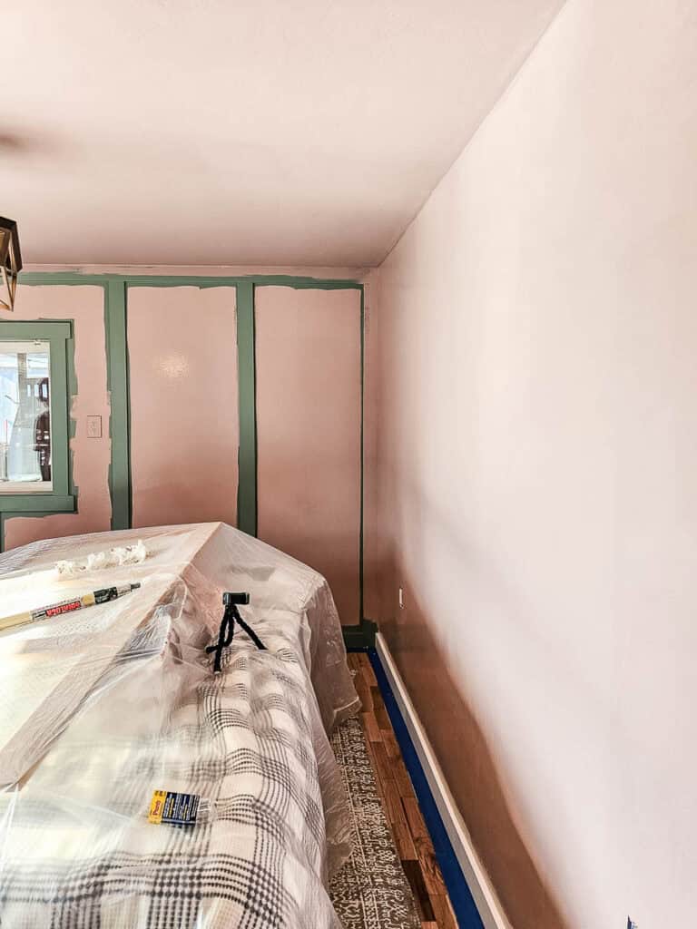 A bedroom with a pink wall