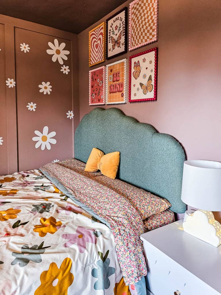 The completed handcrafted cloud headboard in floral bedding for little girl with pink walls