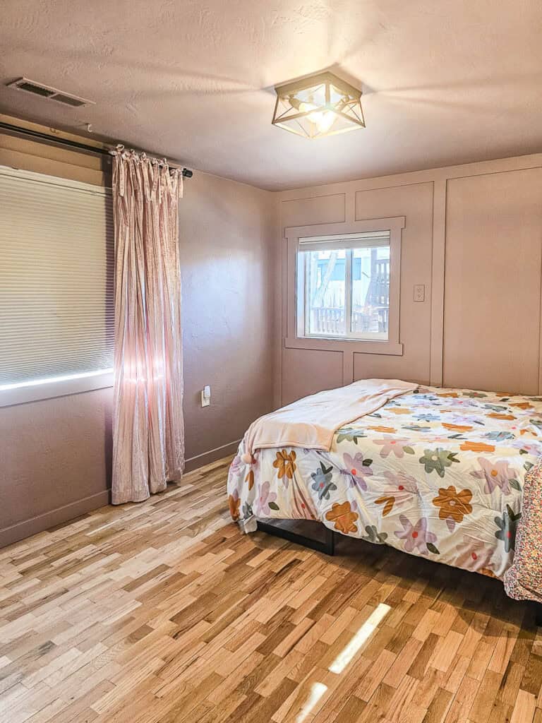 After photo showcasing the bedroom with pink walls.
