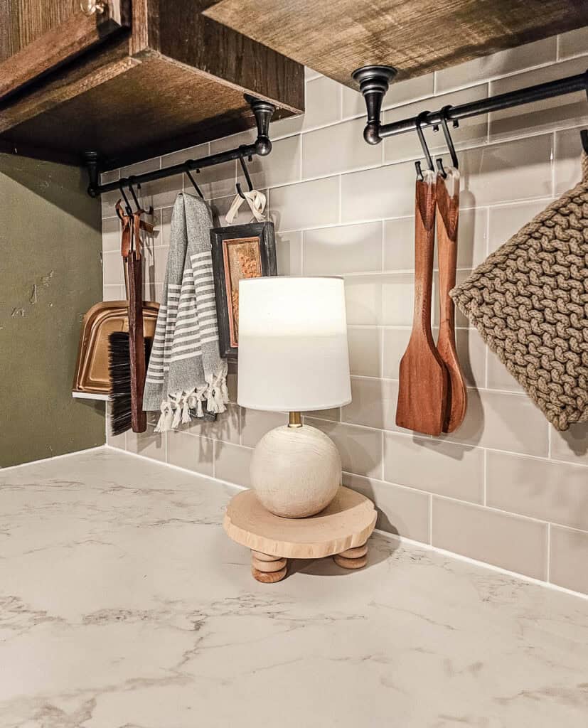 A photo of a finished wooden riser with a lamp on it, placed in the kitchen.