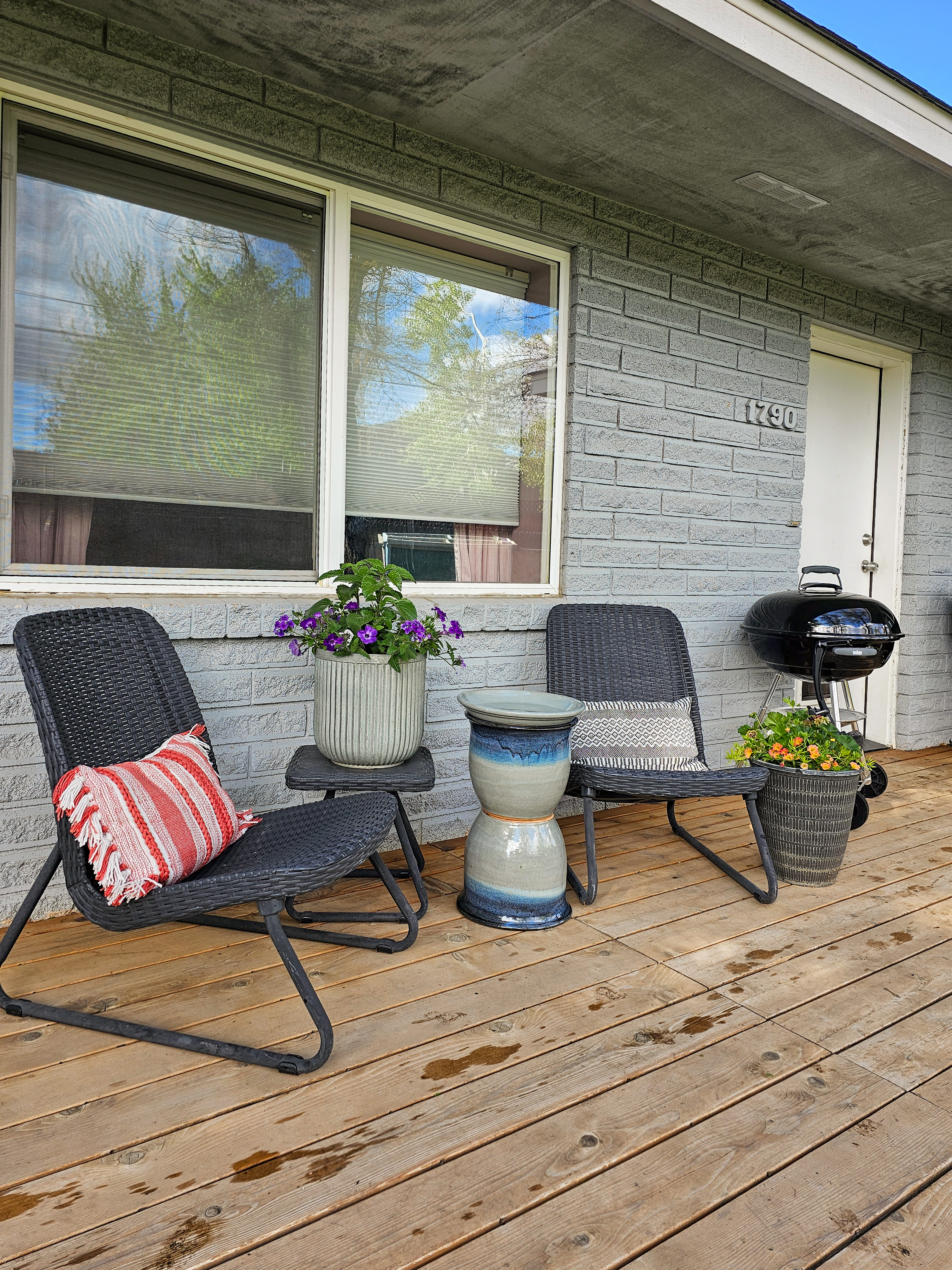 Photo of a patio side table positioned between two chairs outside the house.

