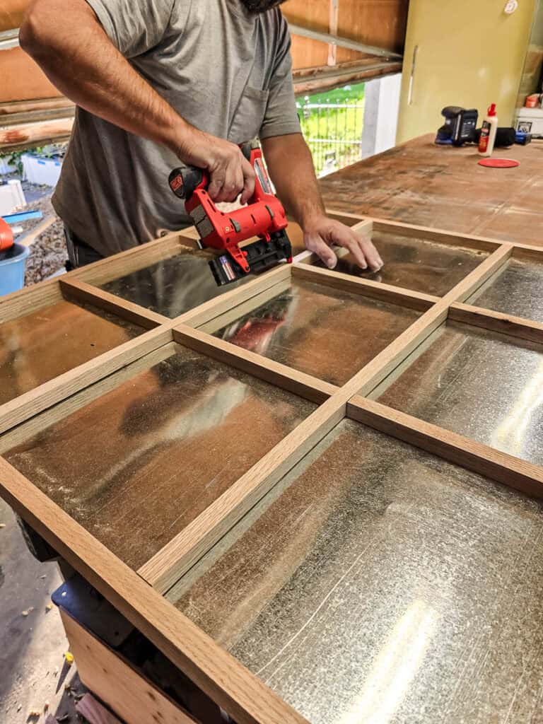 A man assembled grid inside the frame of the tic tac toe board