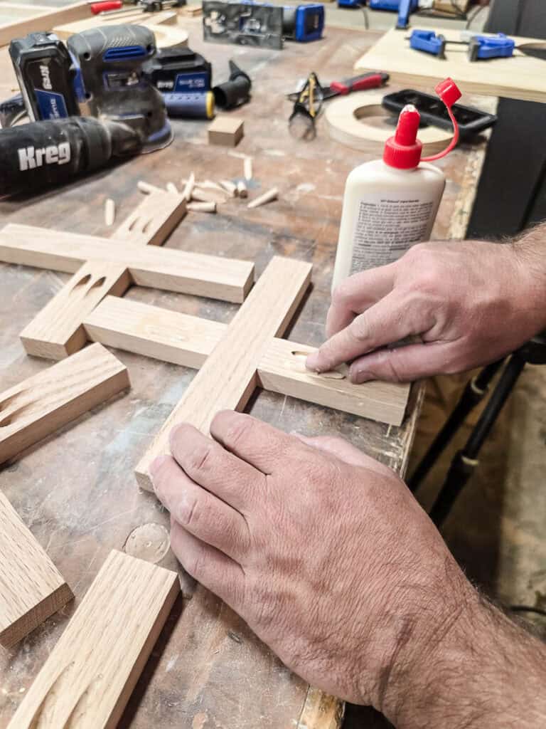 Filling pocket holes and smoothing the X pieces with a router.