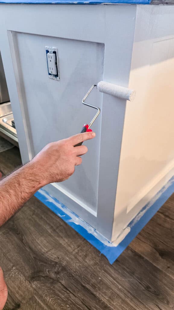 applying bonding primer to kitchen cabinets with mini roller