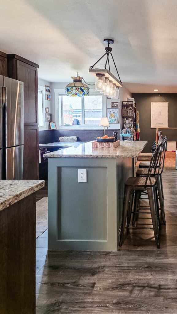 Finished kitchen island painted in a soft gray-green color with a granite countertop, showcasing the completed DIY kitchen island makeover in a modern farmhouse kitchen.